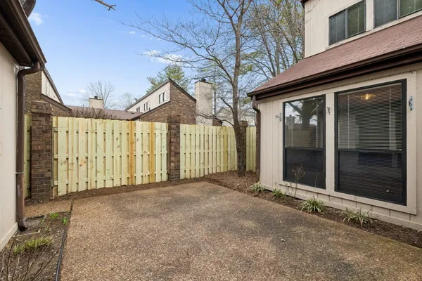 a view of a house with a large windows and wooden fence