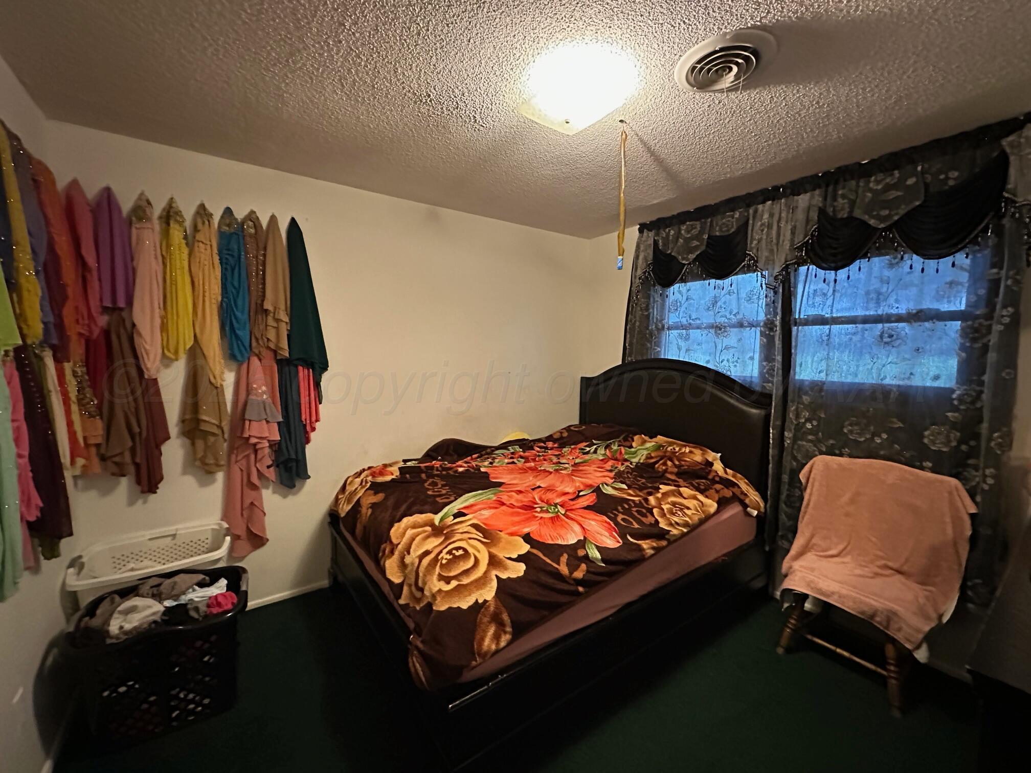1607 Evergreen Street Amarillo, TX 79107 - Photo 12 of 18 a bedroom with a bed a chair and a closet