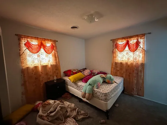 a bed sitting in a bedroom next to a window