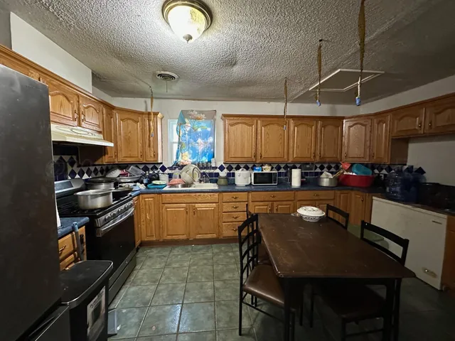 a kitchen with a table chairs microwave and cabinets