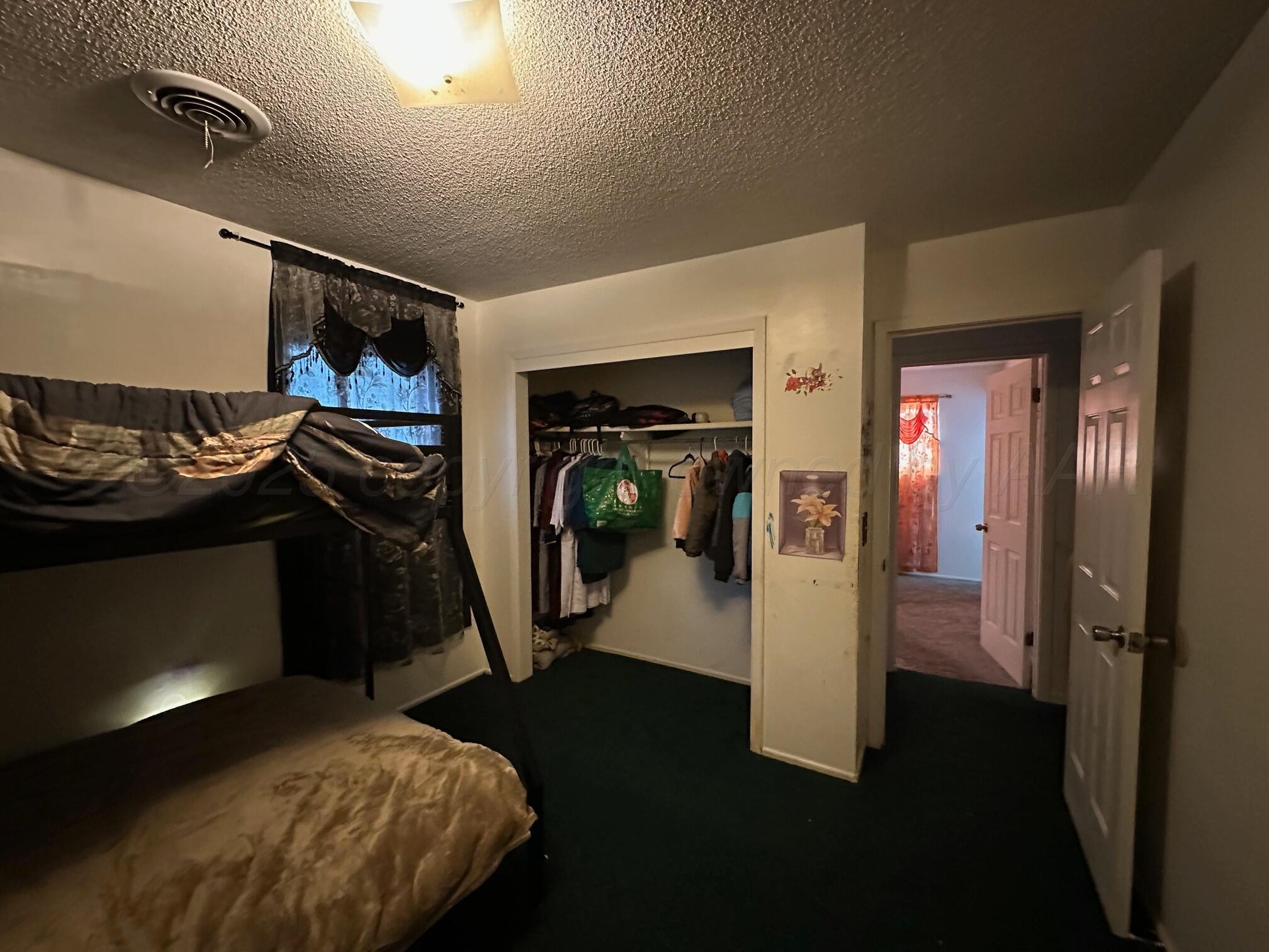 1607 Evergreen Street Amarillo, TX 79107 - Photo 9 of 18 a bedroom with a bed and a mirror