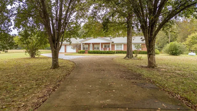 a view of an house with backyard and trees