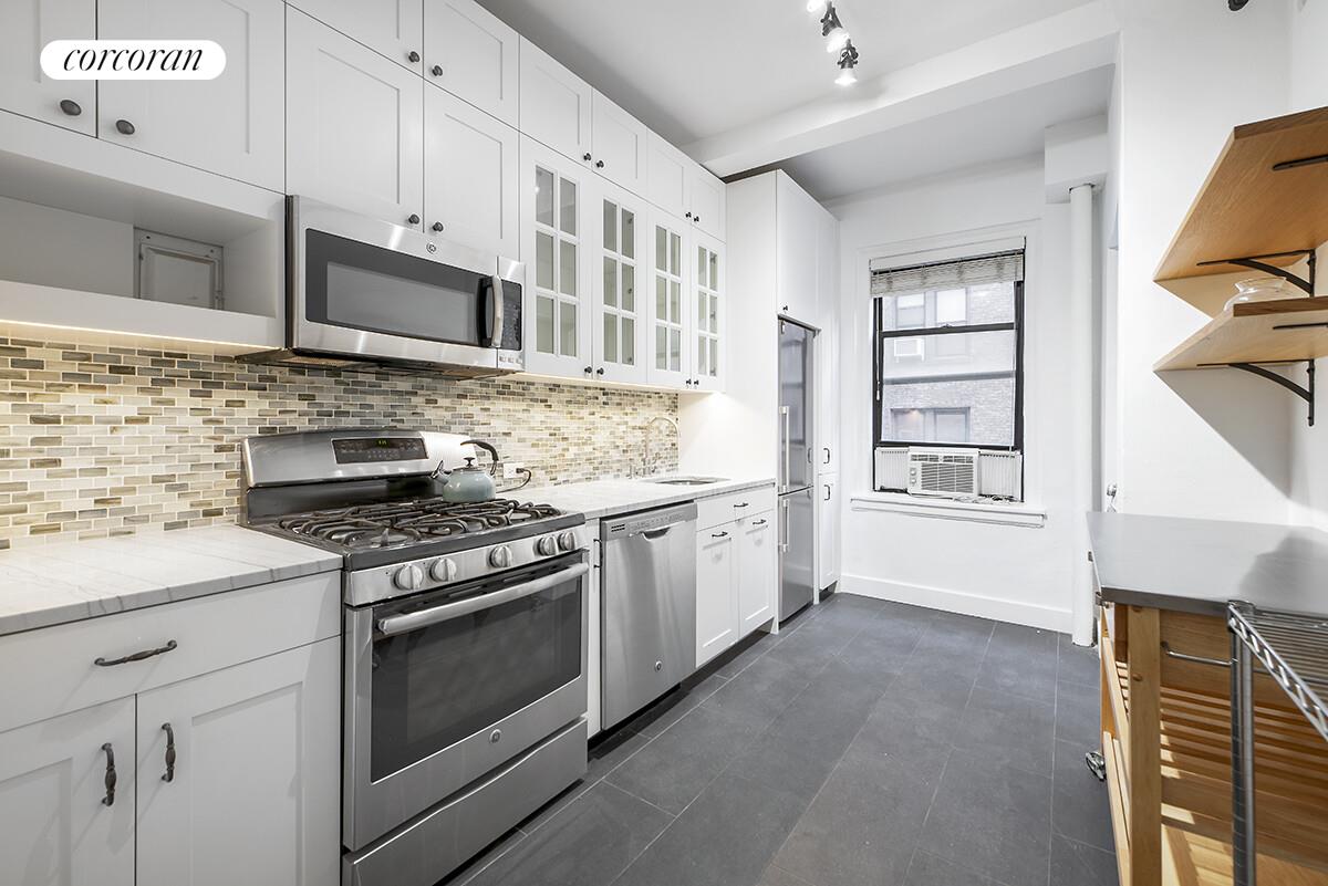 535 West 110th Street, Unit 4A Manhattan, NY 10025 - Photo 7 of 12 a kitchen with stainless steel appliances white cabinets and a stove top oven