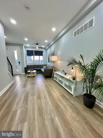 a living room with furniture kitchen view and a potted plant