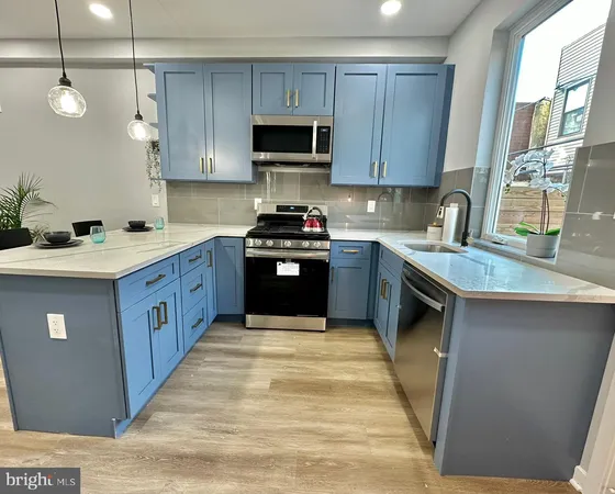 a kitchen with stainless steel appliances granite countertop a sink a stove and a refrigerator