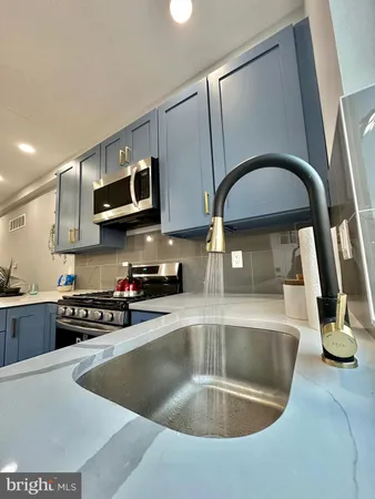 a kitchen with stainless steel appliances granite countertop a sink a stove a refrigerator and island