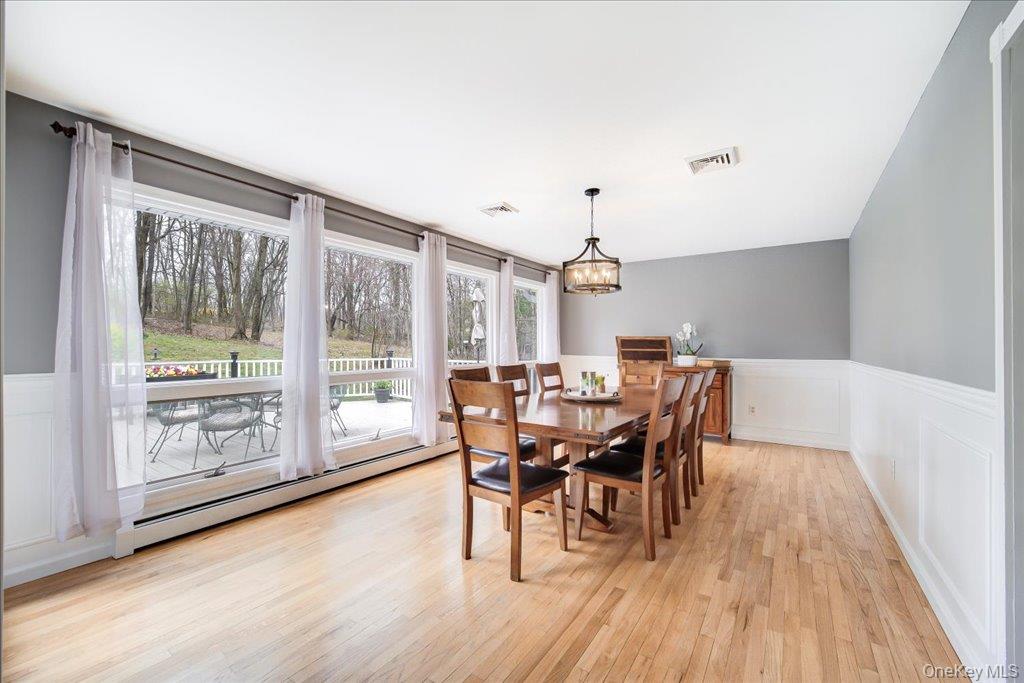 157 Brewer Road Newburgh, NY 12550 - Photo 11 of 50 Spacious dining area featuring hardwood floors, wainscoting, and large windows offering views of the outdoors