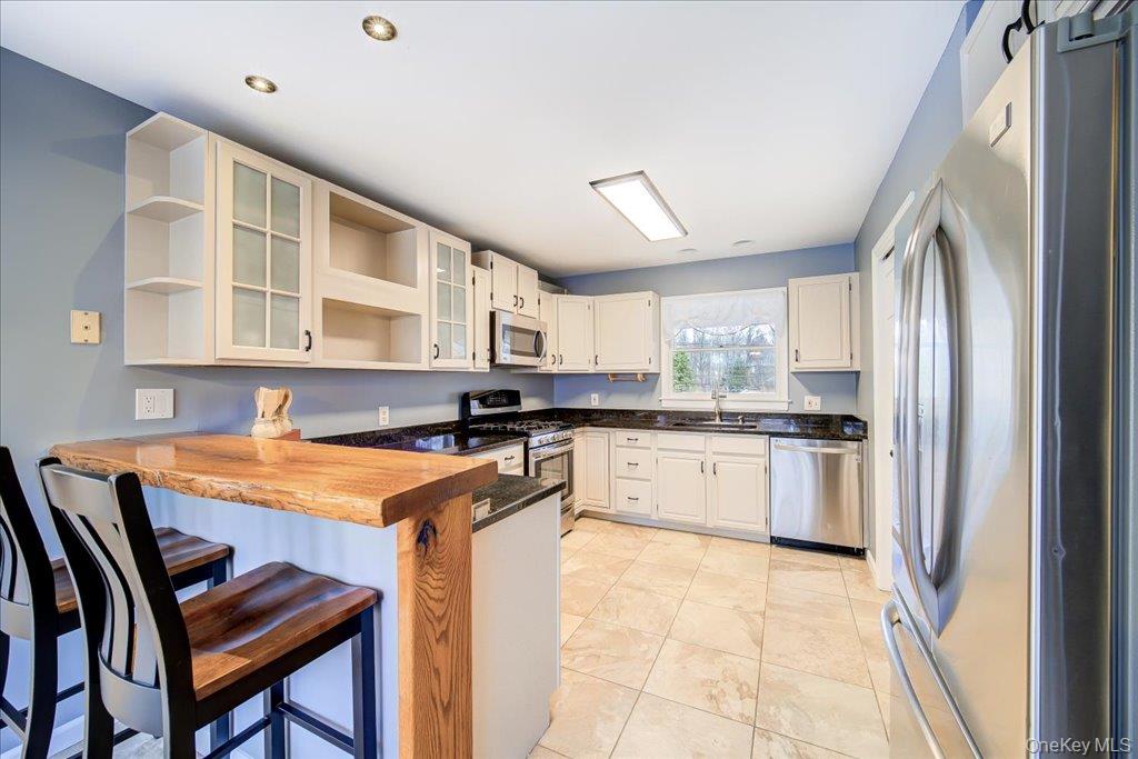 157 Brewer Road Newburgh, NY 12550 - Photo 15 of 50 Well-appointed kitchen featuring light-colored cabinetry, black countertops, and stainless steel appliances including a refrigerator, dishwasher, and microwave