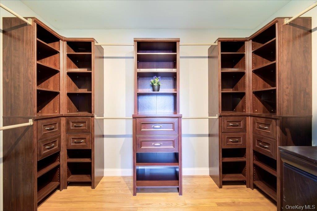 157 Brewer Road Newburgh, NY 12550 - Photo 24 of 50 Custom closet system featuring rich wood cabinetry, ample shelving, integrated drawers, and hanging rods