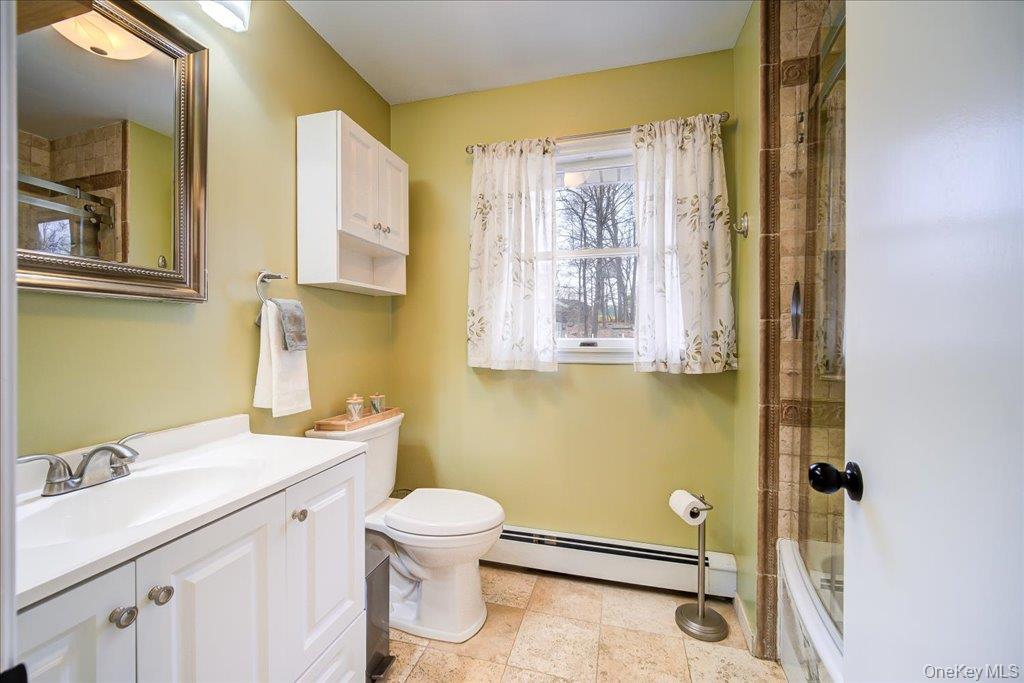 157 Brewer Road Newburgh, NY 12550 - Photo 25 of 50 Bathroom featuring a vanity with a white countertop and white cabinetry, a toilet, a window with curtains, and tiled flooring