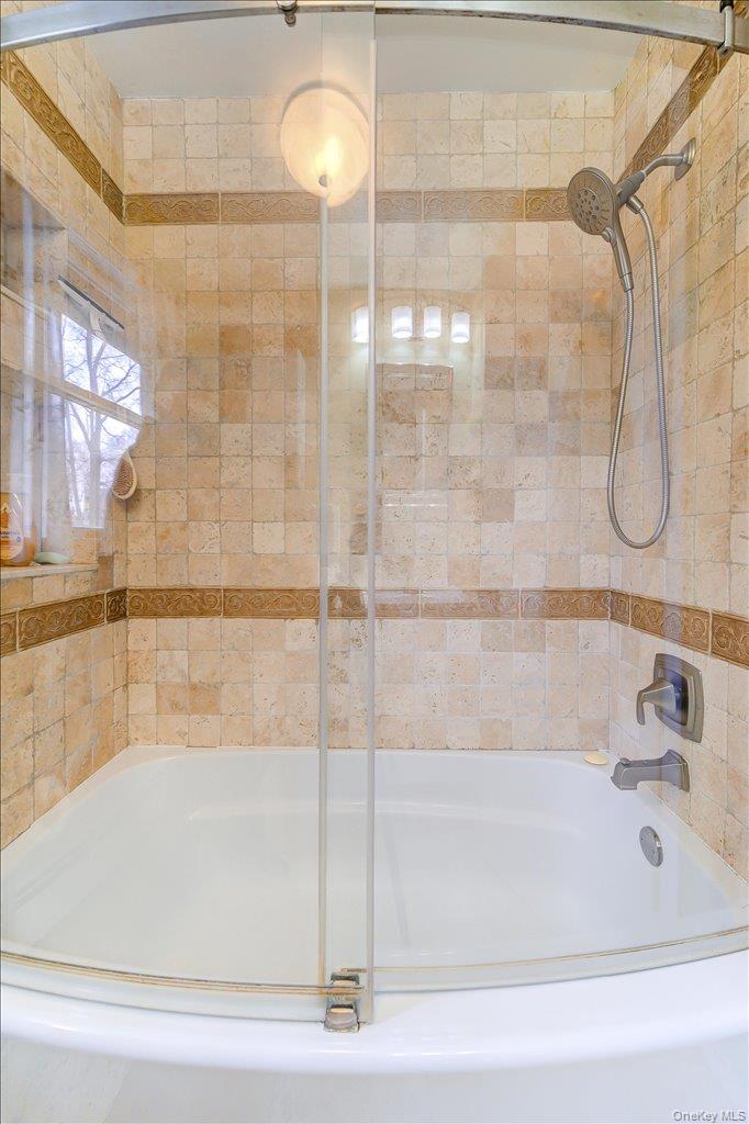 157 Brewer Road Newburgh, NY 12550 - Photo 26 of 50 Bathroom featuring a white bathtub with a clear sliding glass shower door and light-colored tiled walls
