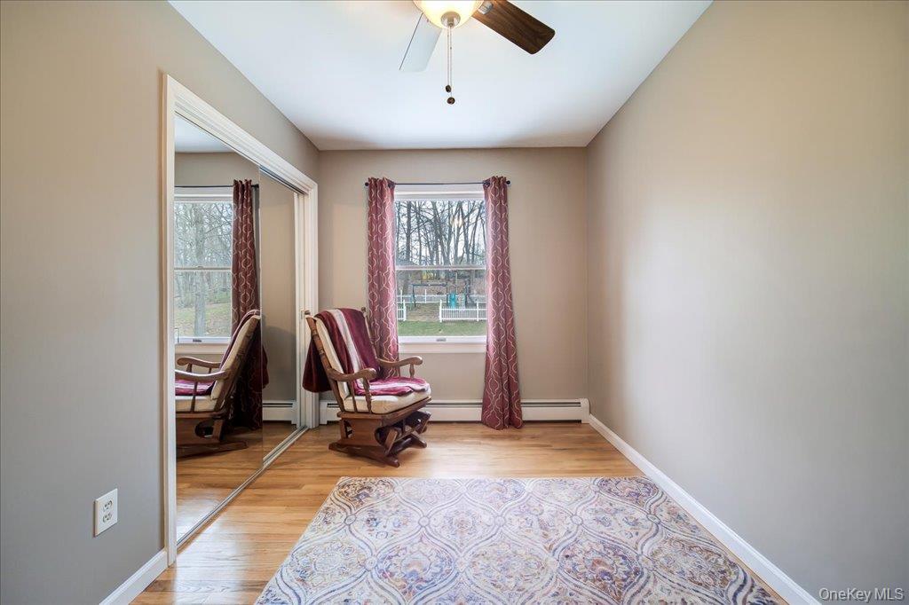 157 Brewer Road Newburgh, NY 12550 - Photo 27 of 50 This room features hardwood floors, a window with views of trees, and a ceiling fan
