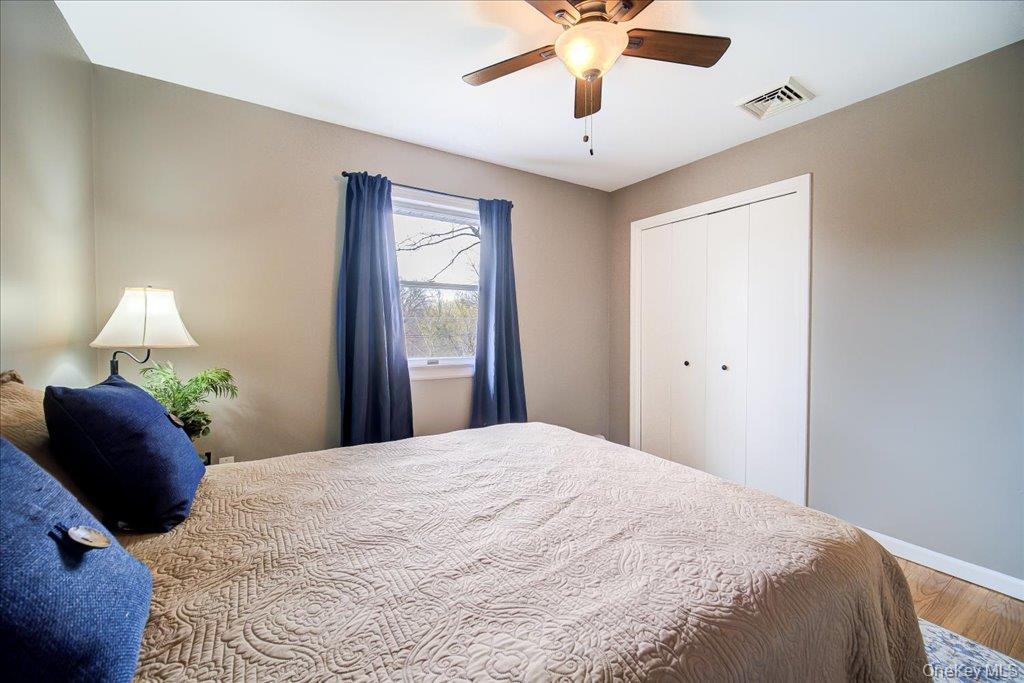 157 Brewer Road Newburgh, NY 12550 - Photo 30 of 50 This inviting room features a window with blue curtains, a ceiling fan with lighting, and a closet with white bi-fold doors