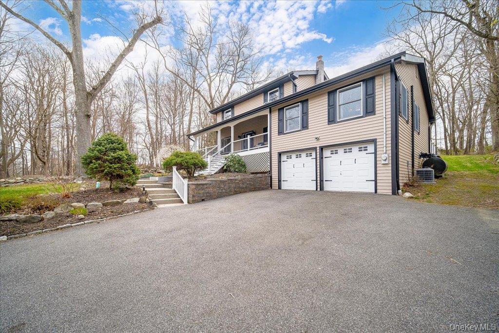 157 Brewer Road Newburgh, NY 12550 - Photo 3 of 50 This property features a two-car garage with white doors, a paved driveway, and a front porch with white railings