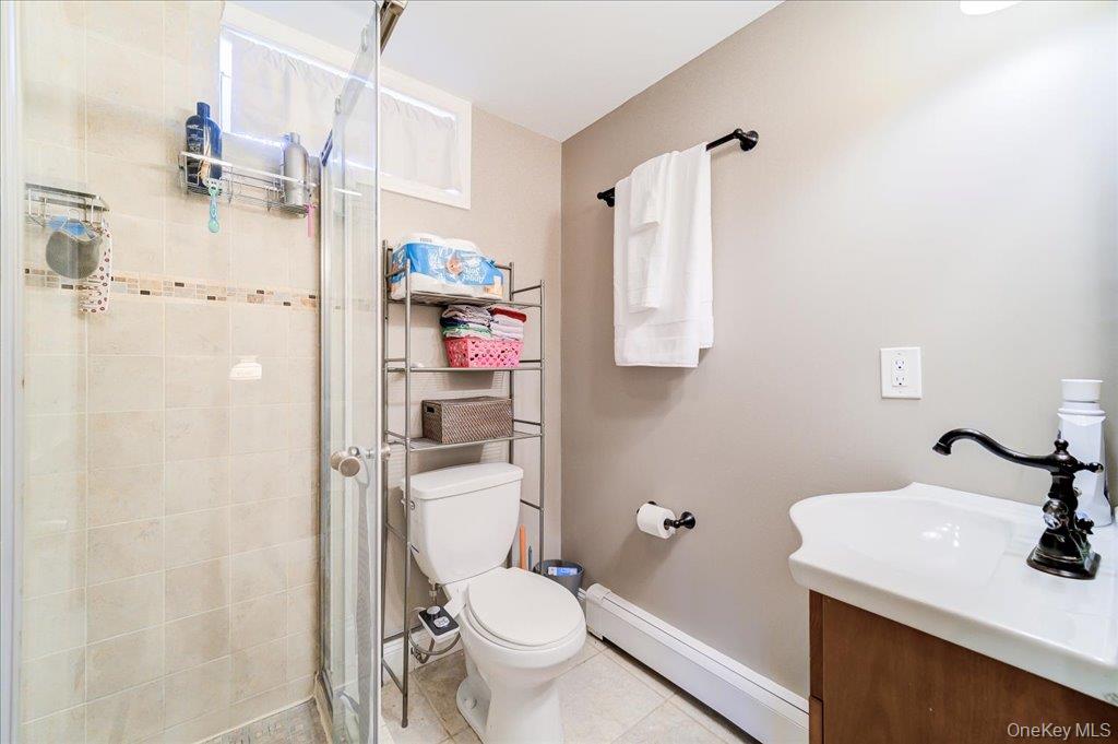 157 Brewer Road Newburgh, NY 12550 - Photo 33 of 50 The bathroom features a tiled shower with a glass enclosure, a toilet, and a vanity with a white sink and a dark-toned faucet