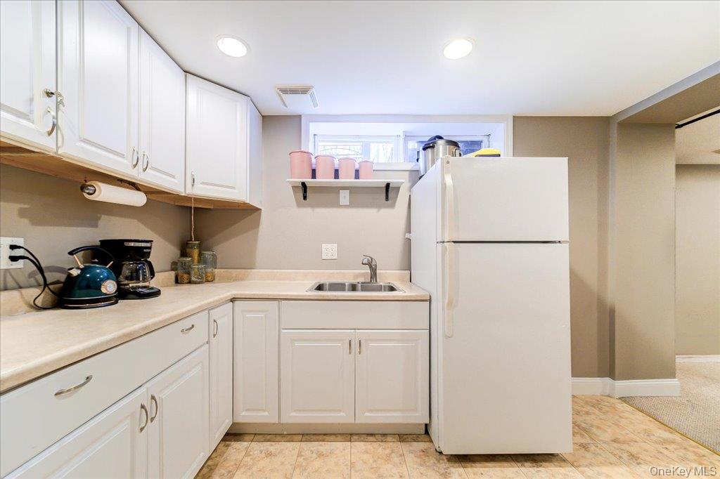 157 Brewer Road Newburgh, NY 12550 - Photo 35 of 50 This kitchen features white cabinetry, a double basin sink, and a refrigerator