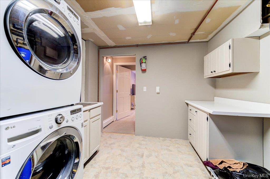 157 Brewer Road Newburgh, NY 12550 - Photo 38 of 50 Dedicated laundry area featuring a stackable washer and dryer, built-in cabinetry, and a countertop space