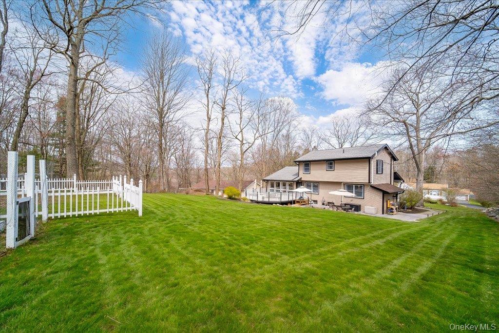 157 Brewer Road Newburgh, NY 12550 - Photo 46 of 50 The property features an expansive green lawn, mature trees, and a white picket fence