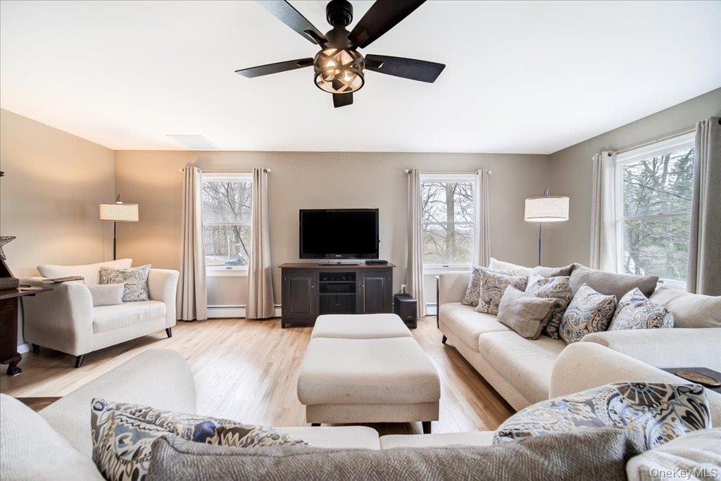 157 Brewer Road Newburgh, NY 12550 - Photo 6 of 50 The living area features hardwood floors, light-colored walls, and a ceiling fan with integrated lighting
