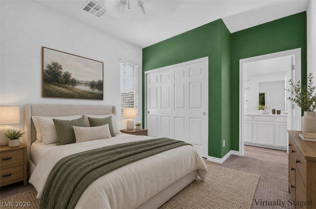 1824 Redland Ridge Street Henderson, NV 89002 - Photo 25 of 69 The carpeted bedroom features a private closet and easy access to a full bathroom, ideal for comfortable living.