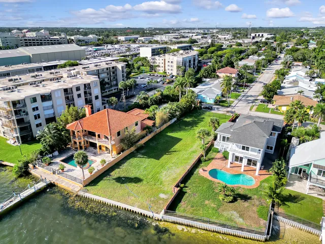 an aerial view of residential houses with outdoor space and a lake view