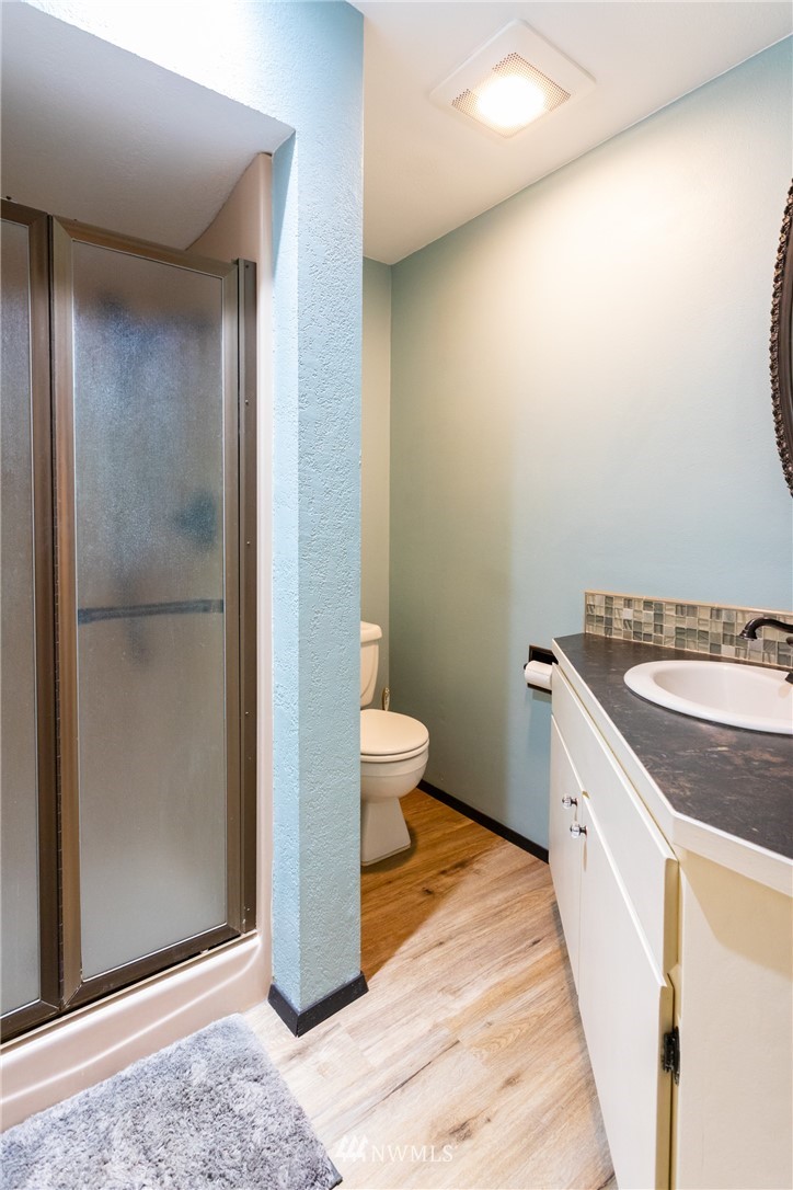 2291 East Pole Road Everson, WA 98247 - Photo 22 of 40 a bathroom with a granite countertop sink a toilet and shower