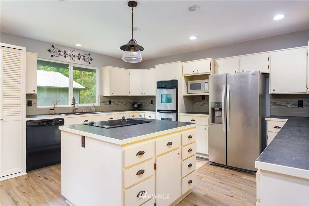 2291 East Pole Road Everson, WA 98247 - Photo 5 of 40 a kitchen with stainless steel appliances granite countertop a stove refrigerator sink and microwave