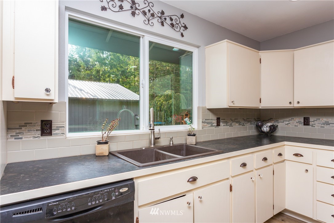 2291 East Pole Road Everson, WA 98247 - Photo 6 of 40 a kitchen with granite countertop a sink and white cabinets