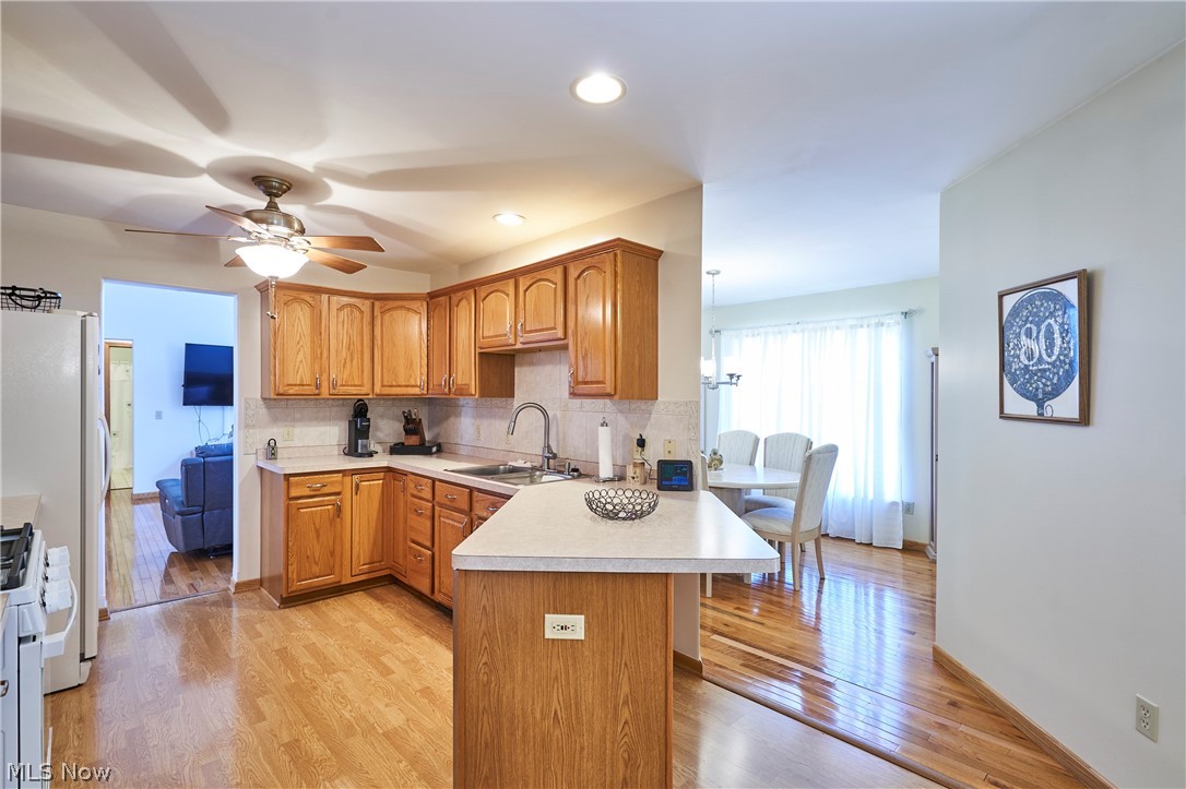 1963 Haines Road Madison, OH 44057 - Photo 5 of 34 Kitchen featuring wood-finish cabinetry, light-toned countertops, and a tile backsplash