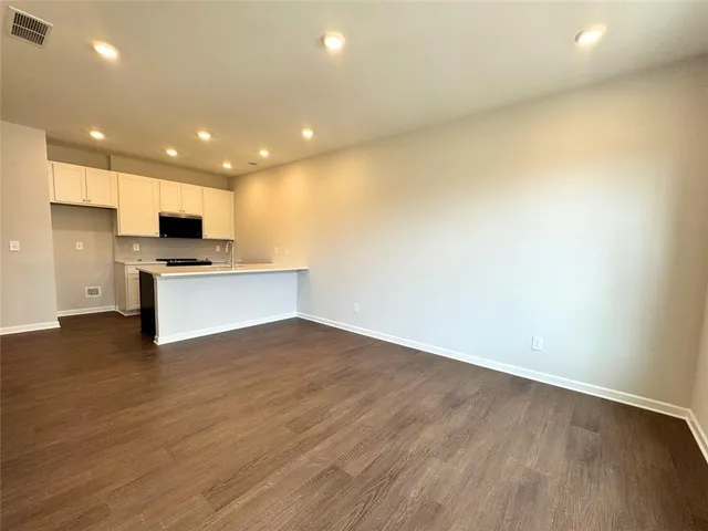 a view of kitchen with wooden floor and electronic appliances