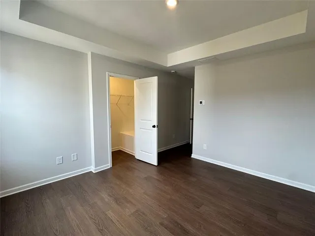 an empty room with wooden floor and closet