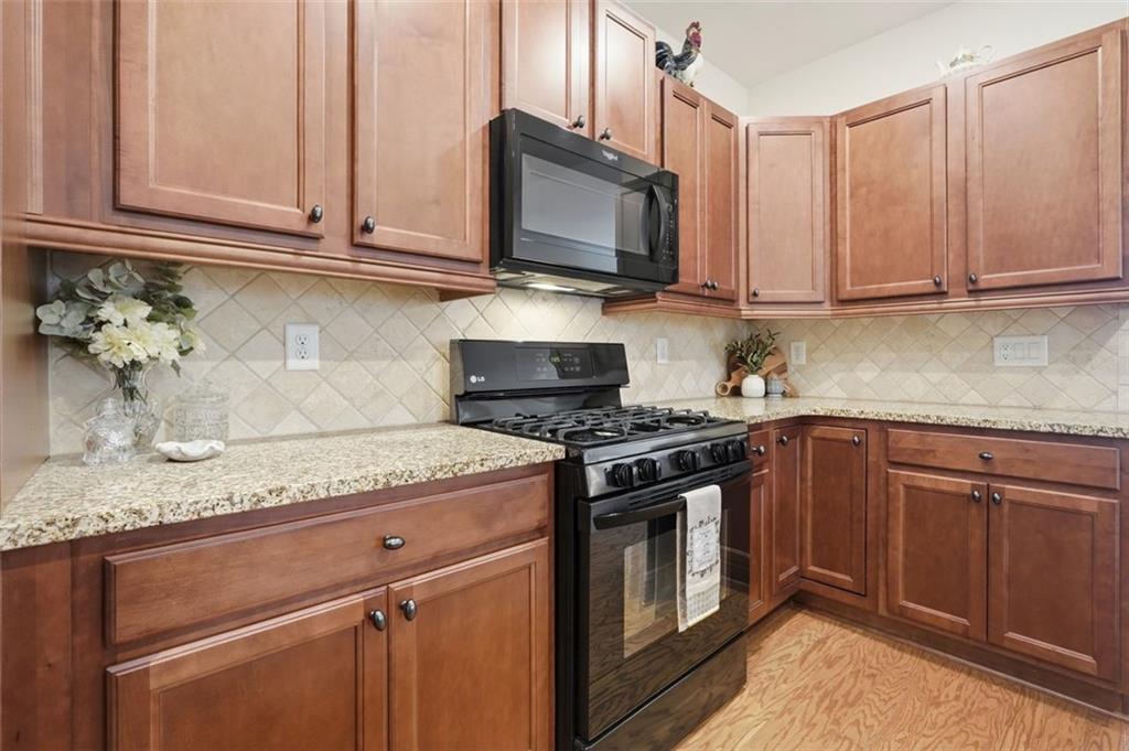 3328 Ivy Ridge Court Buford, GA 30519 - Photo 20 of 34 a kitchen with stainless steel appliances granite countertop a stove a microwave and cabinets