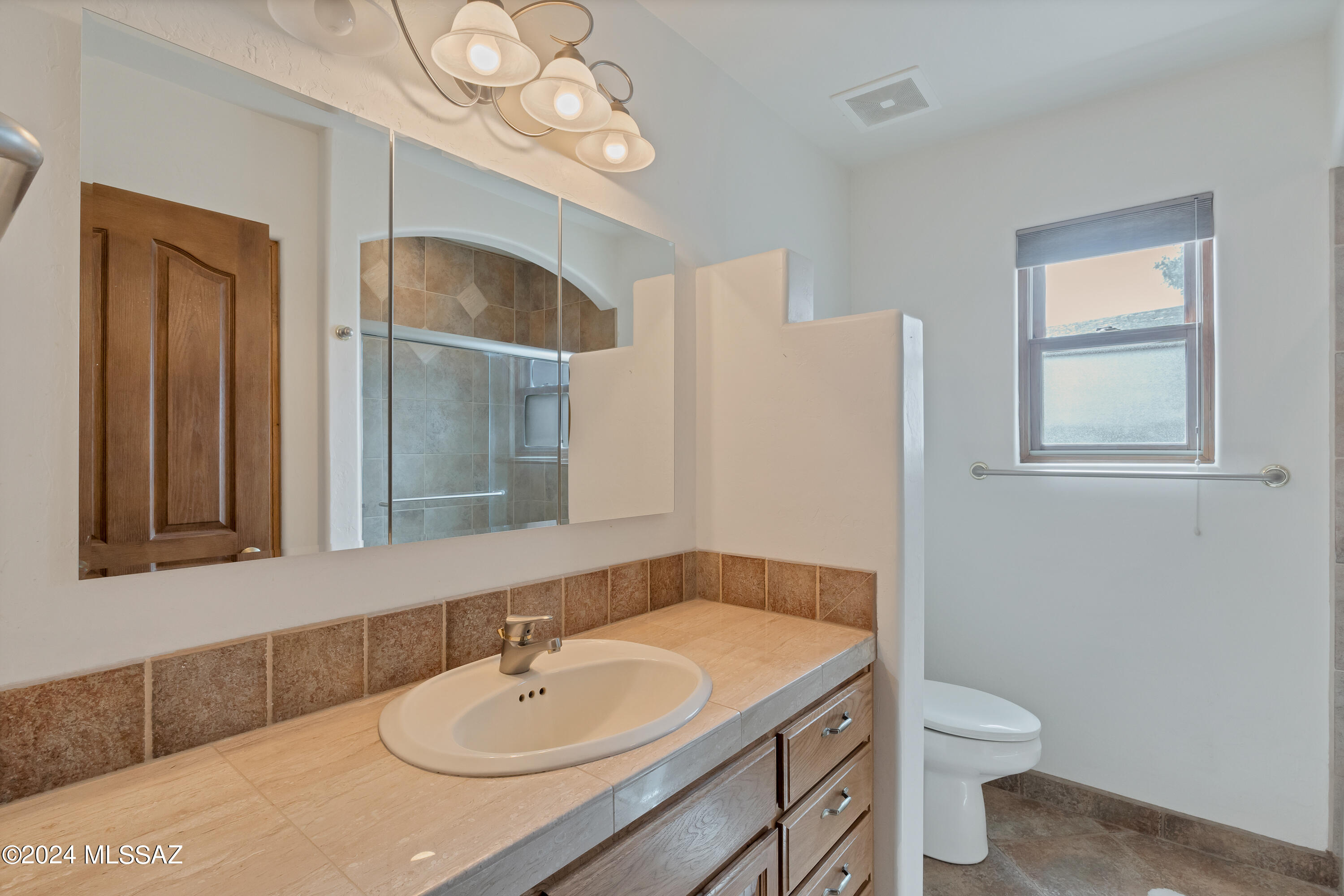 4001 North Harrison Road Tucson, AZ 85749 - Photo 33 of 50 a bathroom with a sink a toilet and a mirror