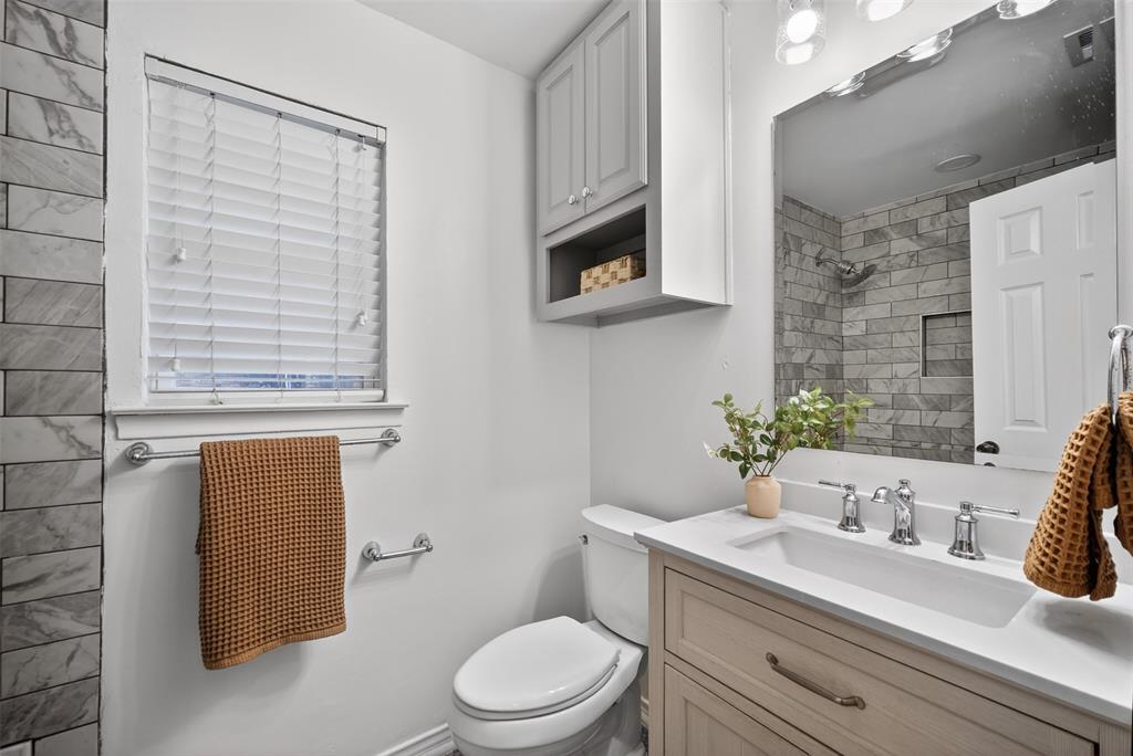 9660 Timberleaf Drive Dallas, TX 75243 - Photo 34 of 40 Bathroom featuring a light wood-finish vanity with a white countertop and undermount sink, complemented by a large mirror and overhead lighting