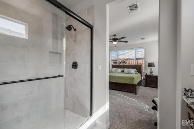 a view of a bedroom with a window and ceiling fan