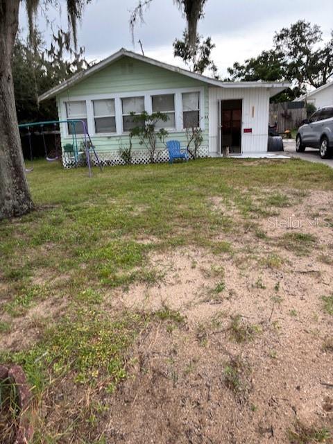 33 West F Street Frostproof, FL 33843 - Photo 1 of 10 a front view of a house with a garden and trees