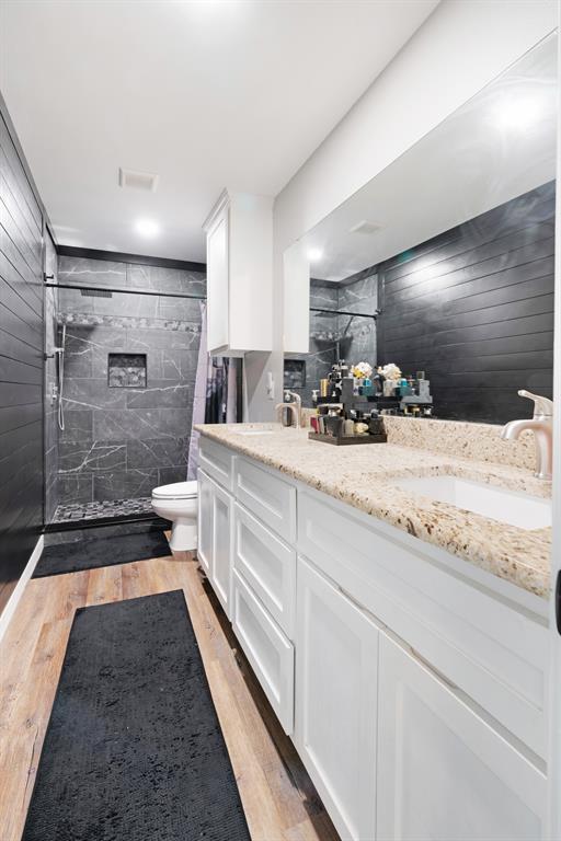 324 Private Road Paris, TX 75462 - Photo 10 of 15 a bathroom with a double vanity sink a toilet a mirror and shower