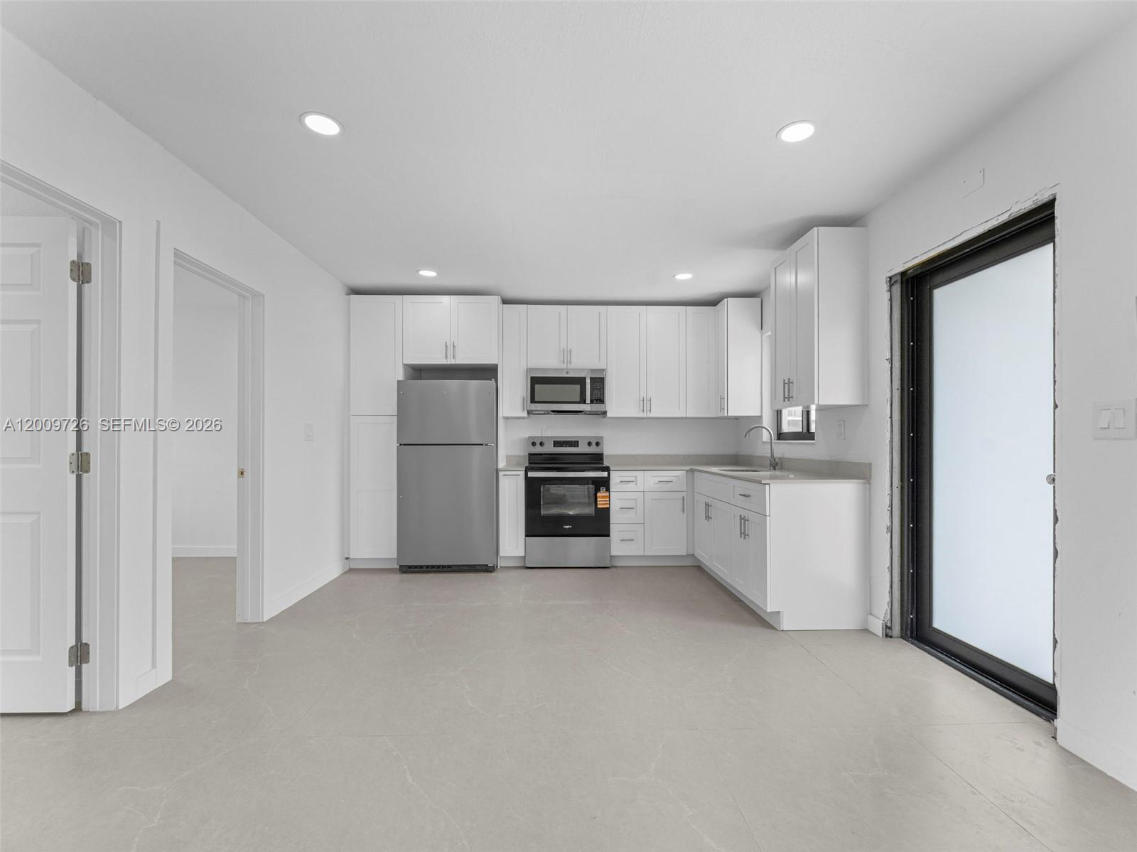 1370 West 29th Street, Unit A Hialeah, FL 33012 - Photo 11 of 16 a view of a kitchen with a sink and dishwasher a refrigerator with white cabinets