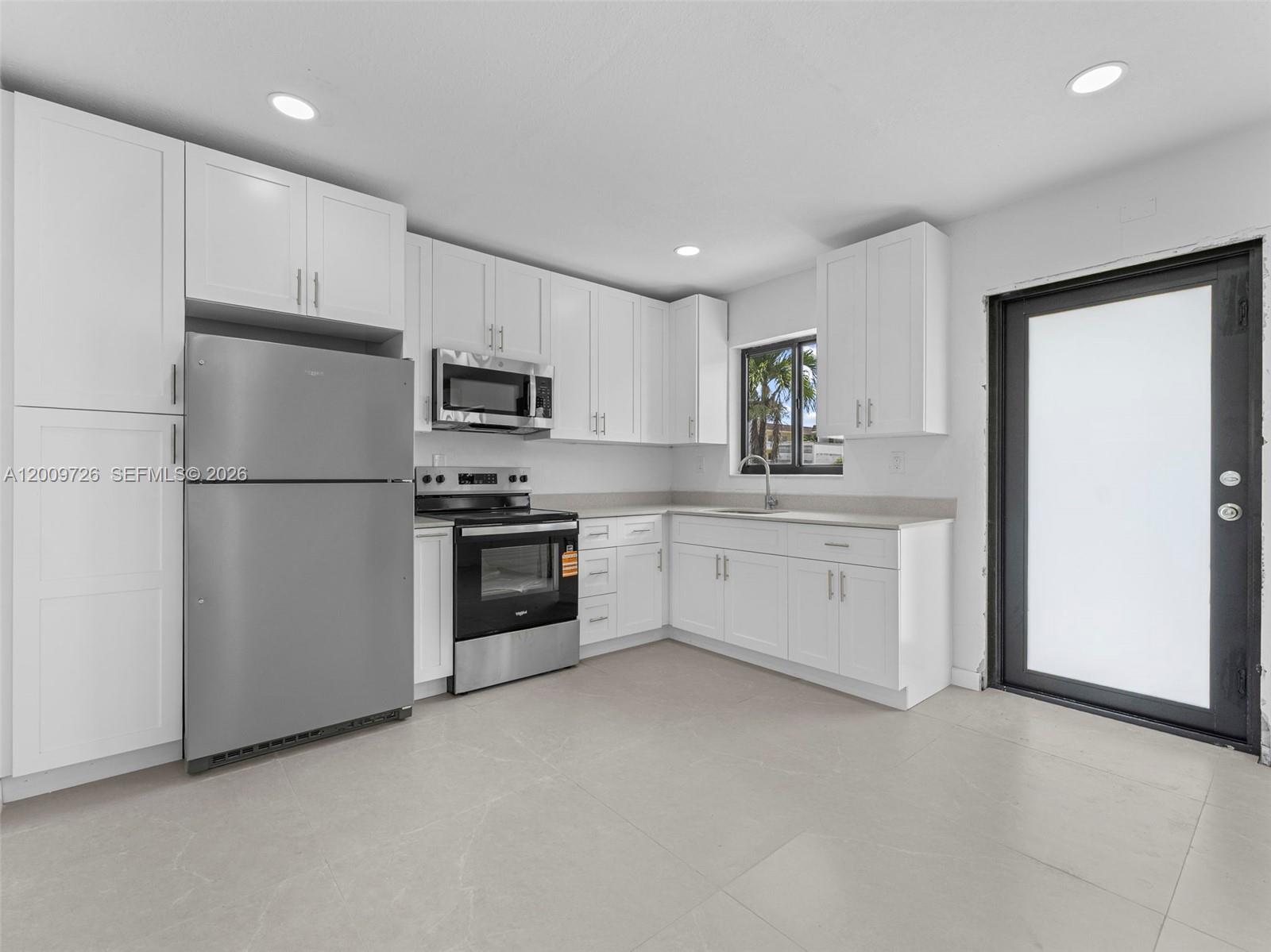 1370 West 29th Street, Unit A Hialeah, FL 33012 - Photo 12 of 16 a kitchen with granite countertop white cabinets and stainless steel appliances