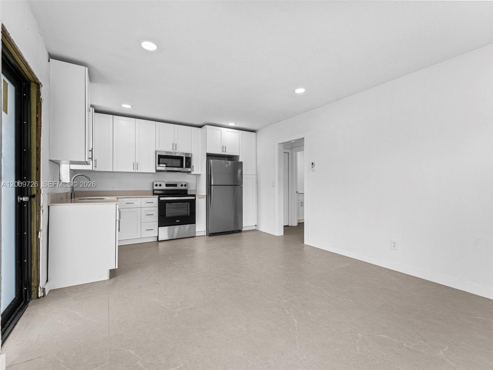 1370 West 29th Street, Unit A Hialeah, FL 33012 - Photo 16 of 16 a view of kitchen with refrigerator stove microwave and cabinets