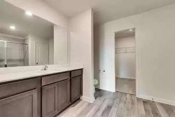 a bathroom with a sink a toilet a mirror and shower