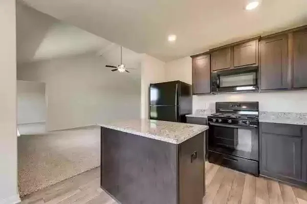 a kitchen with stainless steel appliances granite countertop a refrigerator and a stove