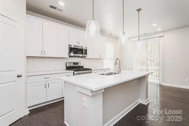 a kitchen with appliances a sink and cabinets