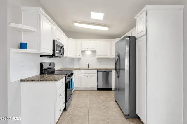 an empty room with ceiling fan and windows