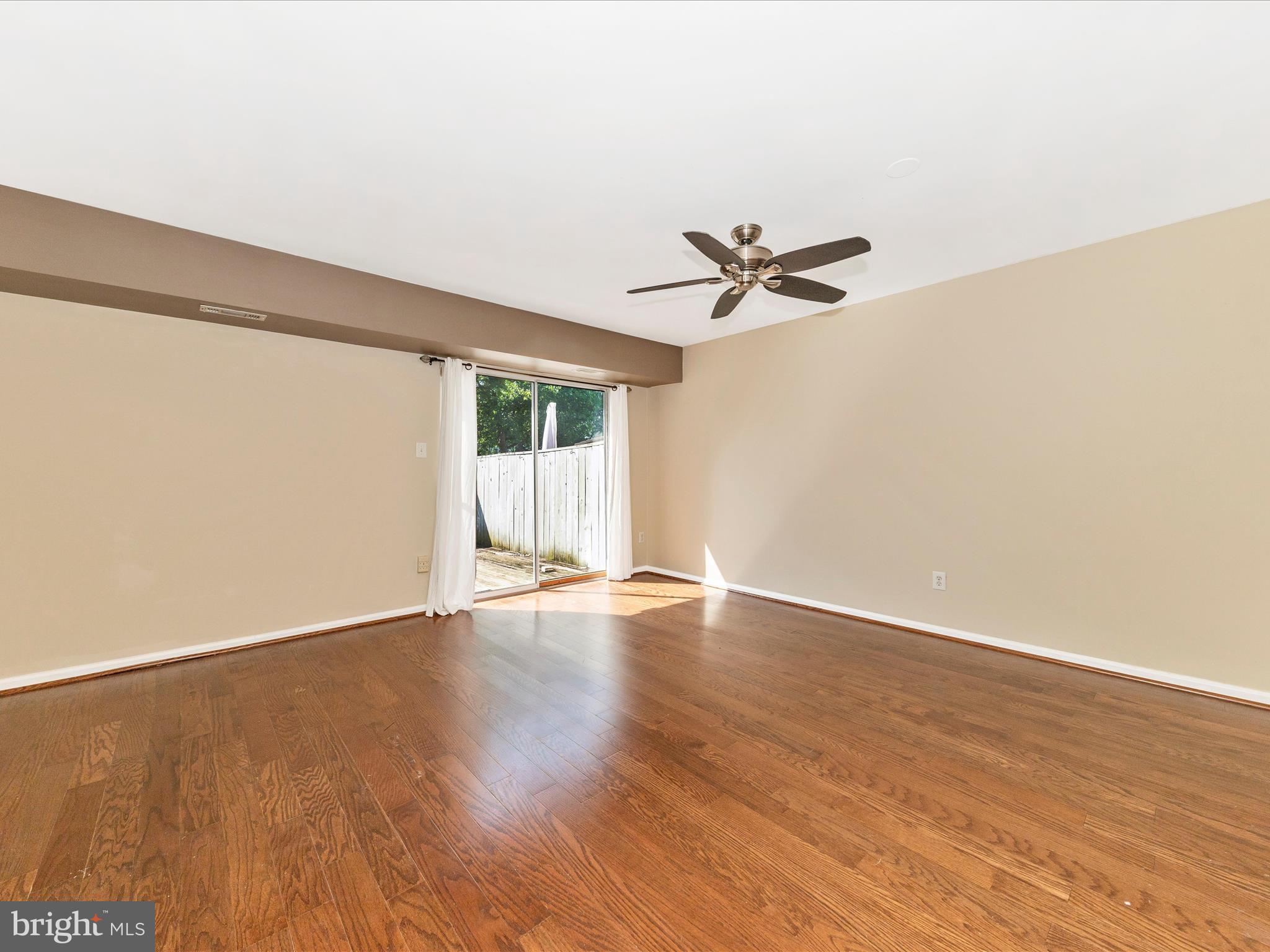 231 Coventry Square, Unit 231 Sterling, VA 20164 - Photo 11 of 40 an empty room with wooden floor and ceiling fan
