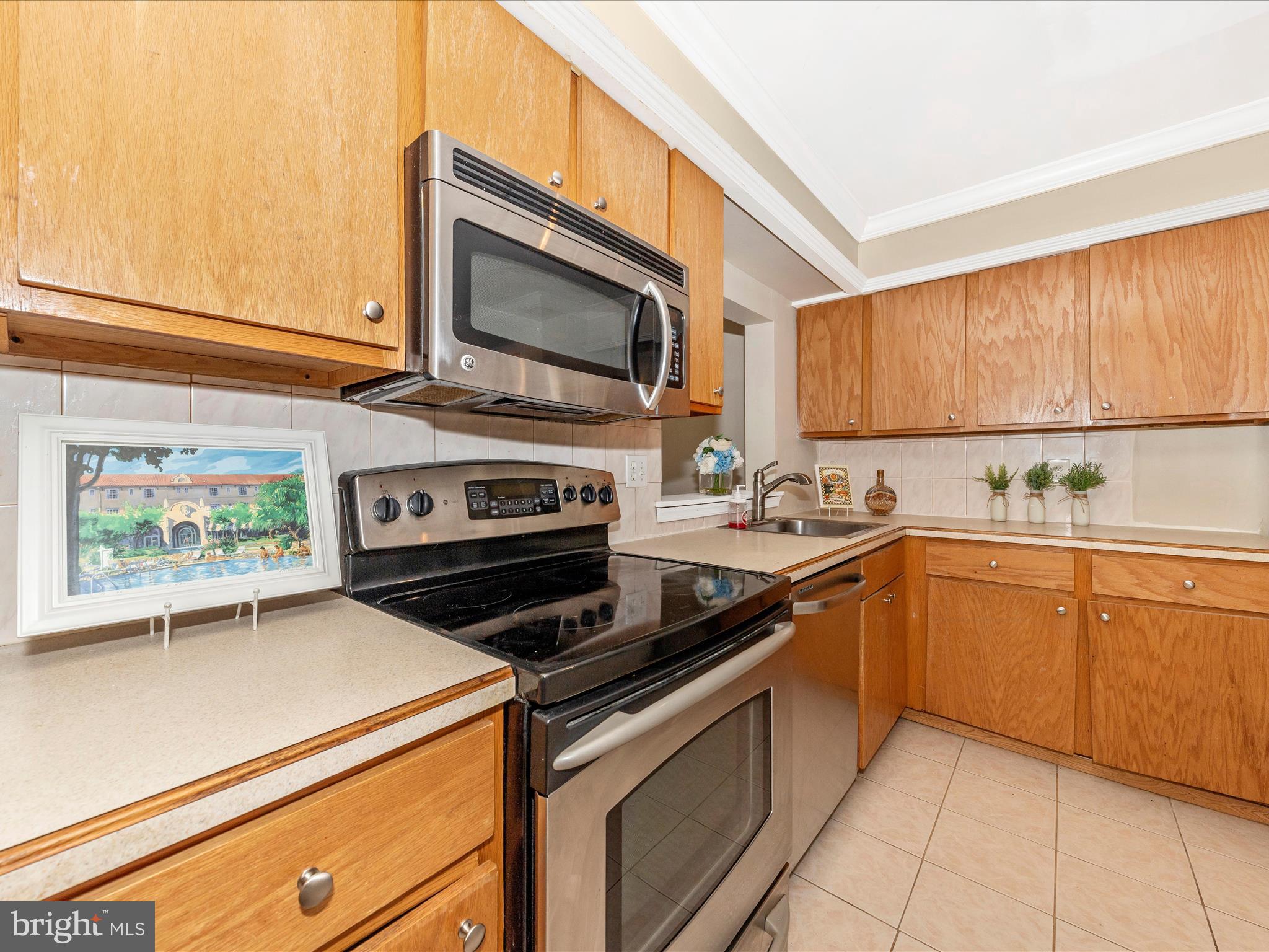231 Coventry Square, Unit 231 Sterling, VA 20164 - Photo 6 of 40 a kitchen with stainless steel appliances a stove microwave and sink