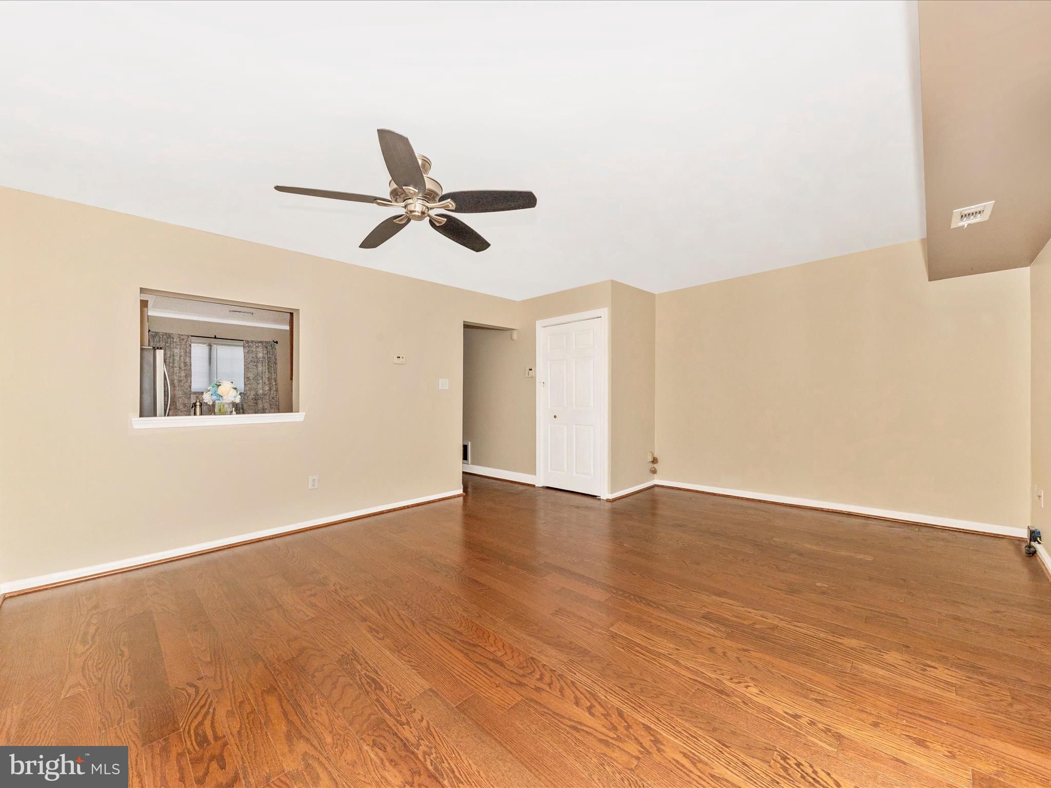 231 Coventry Square, Unit 231 Sterling, VA 20164 - Photo 10 of 40 a view of an empty room with wooden floor and a ceiling fan