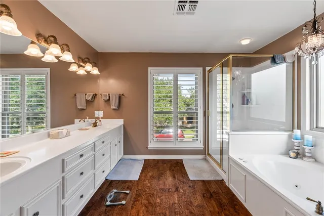 a spacious bathroom with a double vanity sink a large mirror and shower