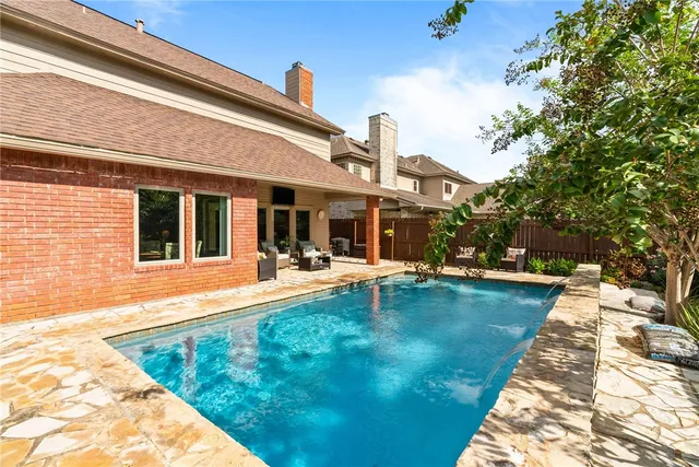 a view of a house with swimming pool and sitting area