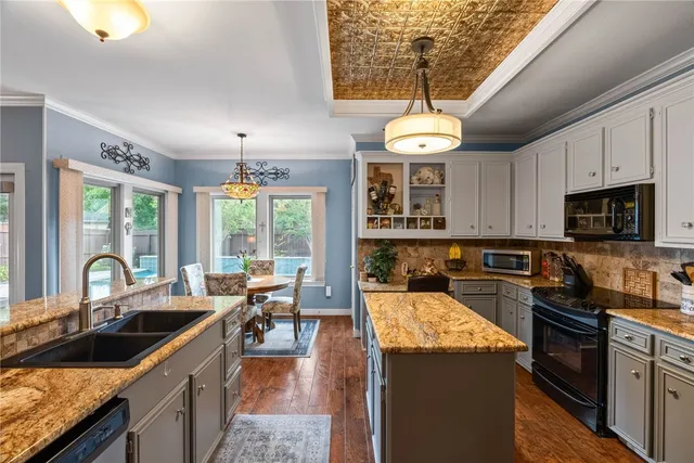 a kitchen with granite countertop a sink and a stove